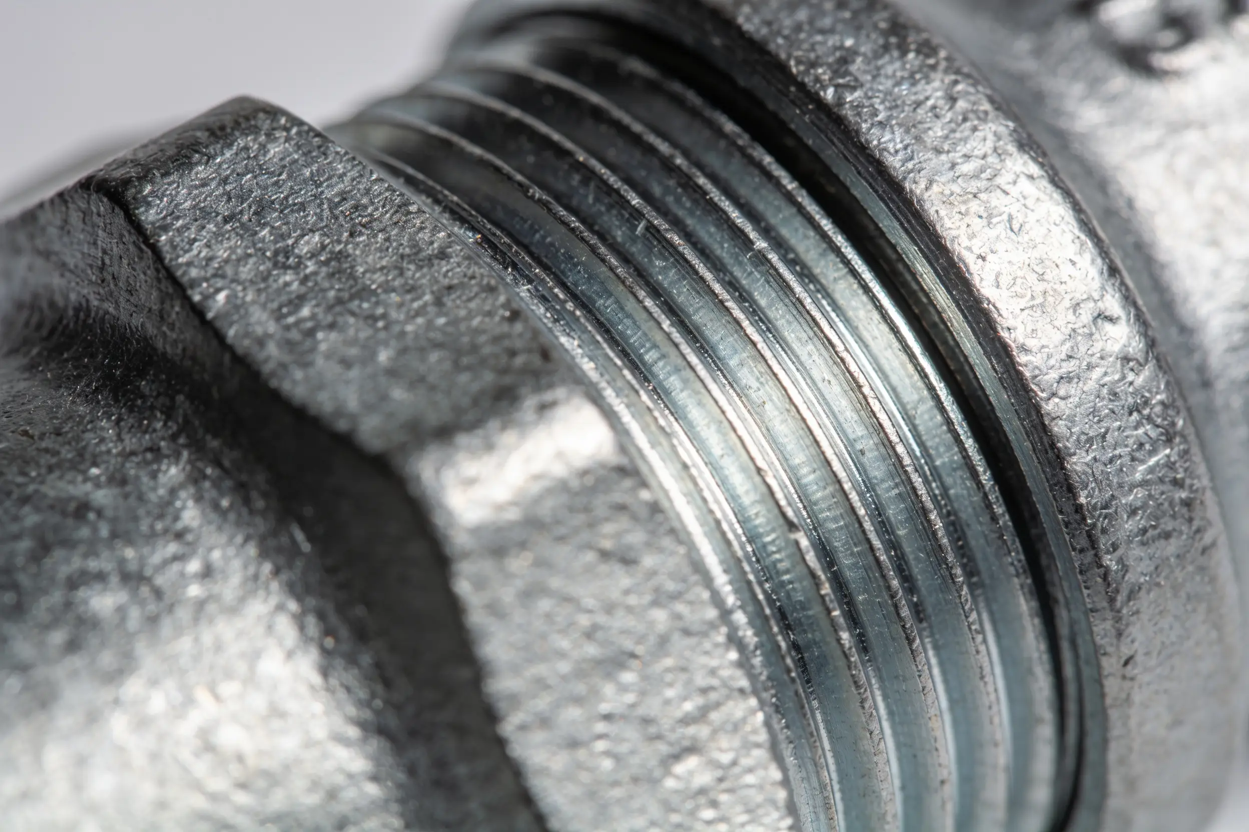 Macro view of the threaded union joint on a galvanised steel water supply pipe