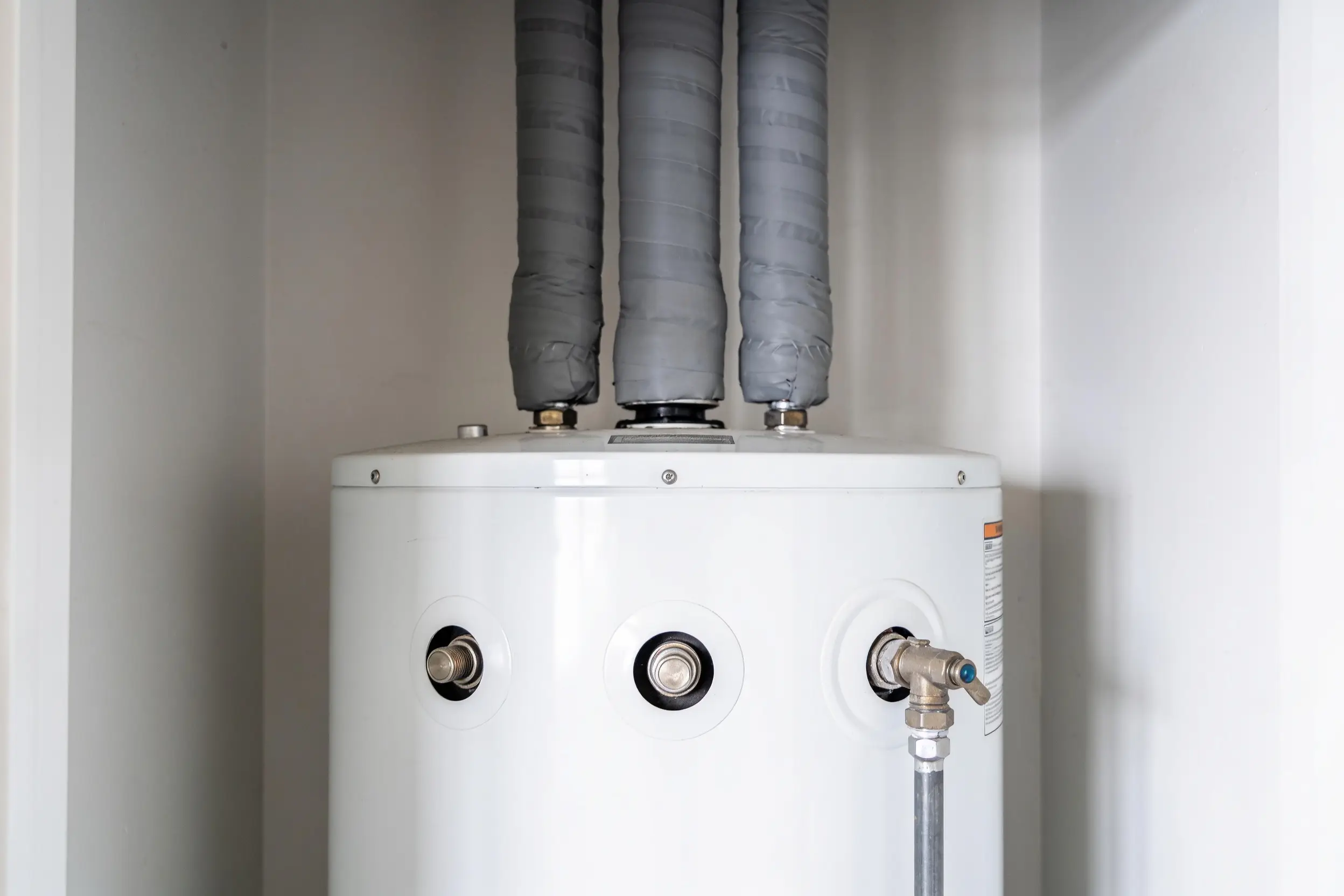 Residential water heater tank with insulated supply connections above it